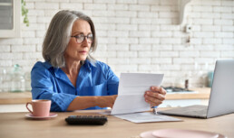 Senior woman checks her bills for late fees